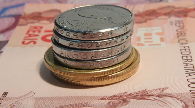 Notas de R$ 10,00. Algumas moedas estão em cima da nota