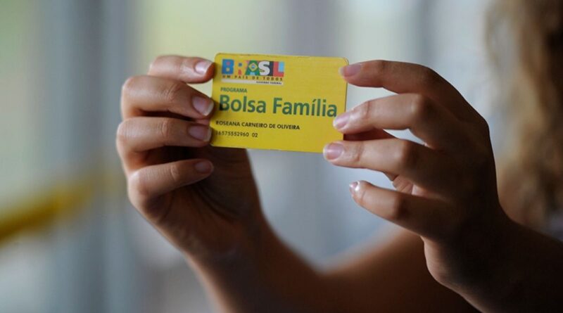 Cartão do Bolsa Família na mão de uma pessoa que recebe auxílio do governo