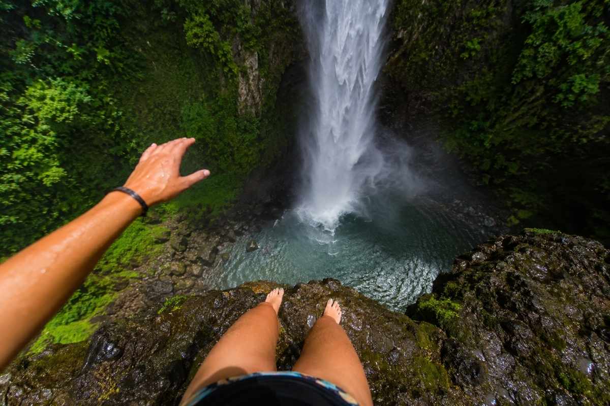 Uma mulher pensando antes de pular na cachoeira