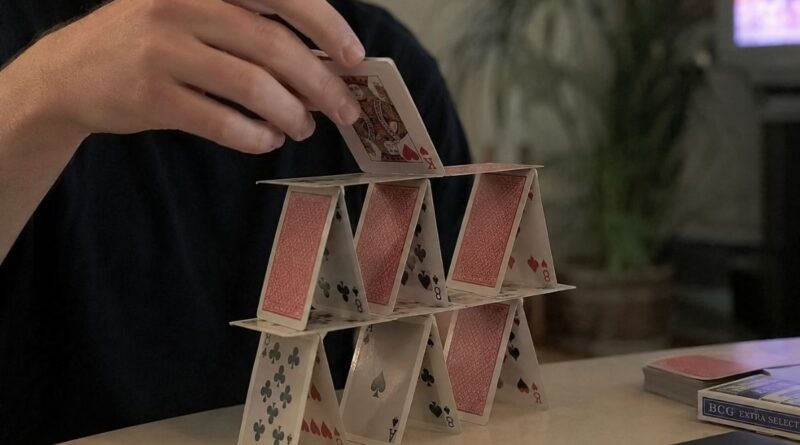Uma pessoa empilhando cartas, trabalhando os pequenos hábitos