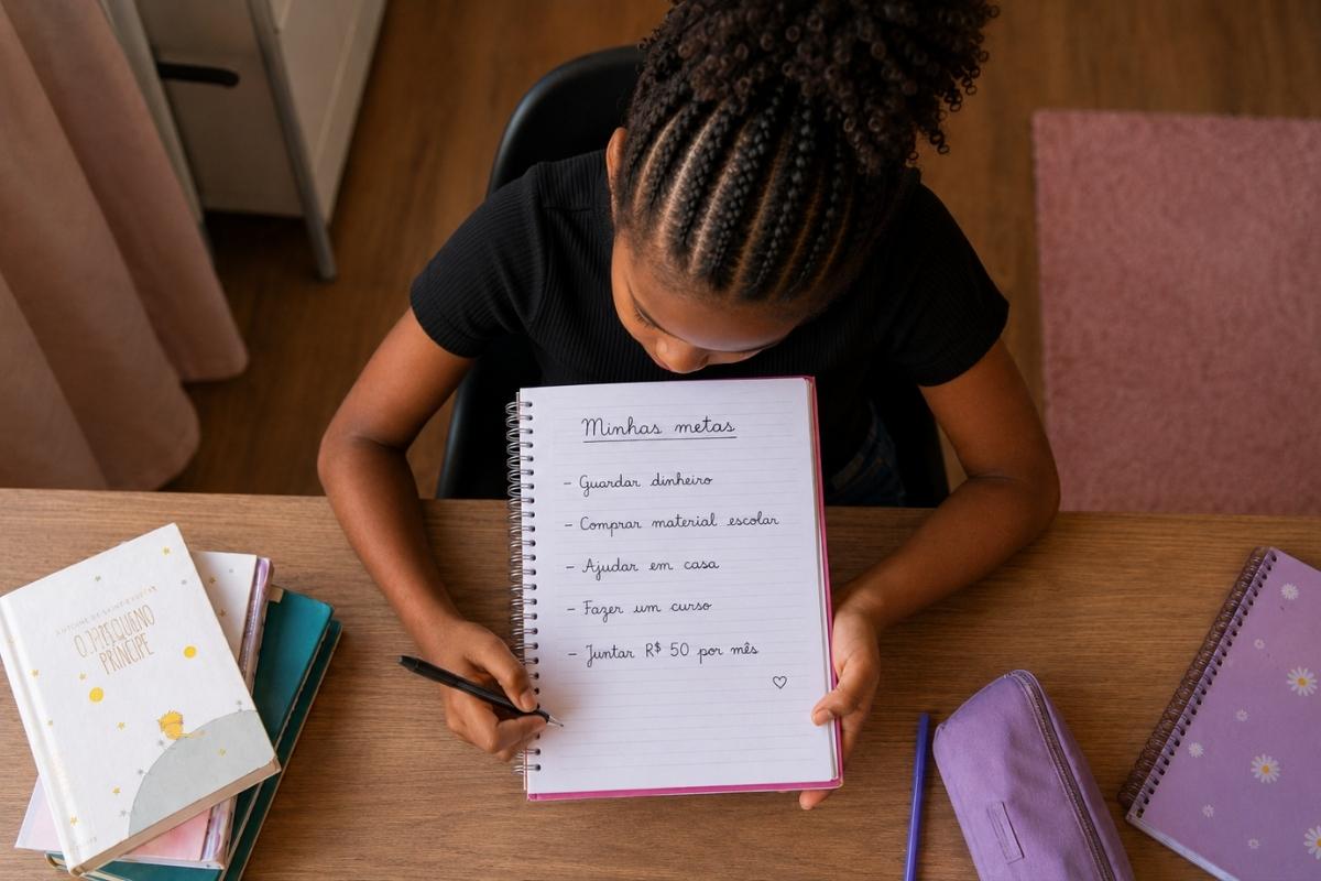 Uma menina segura um caderno com a lista de planejamento financeiro