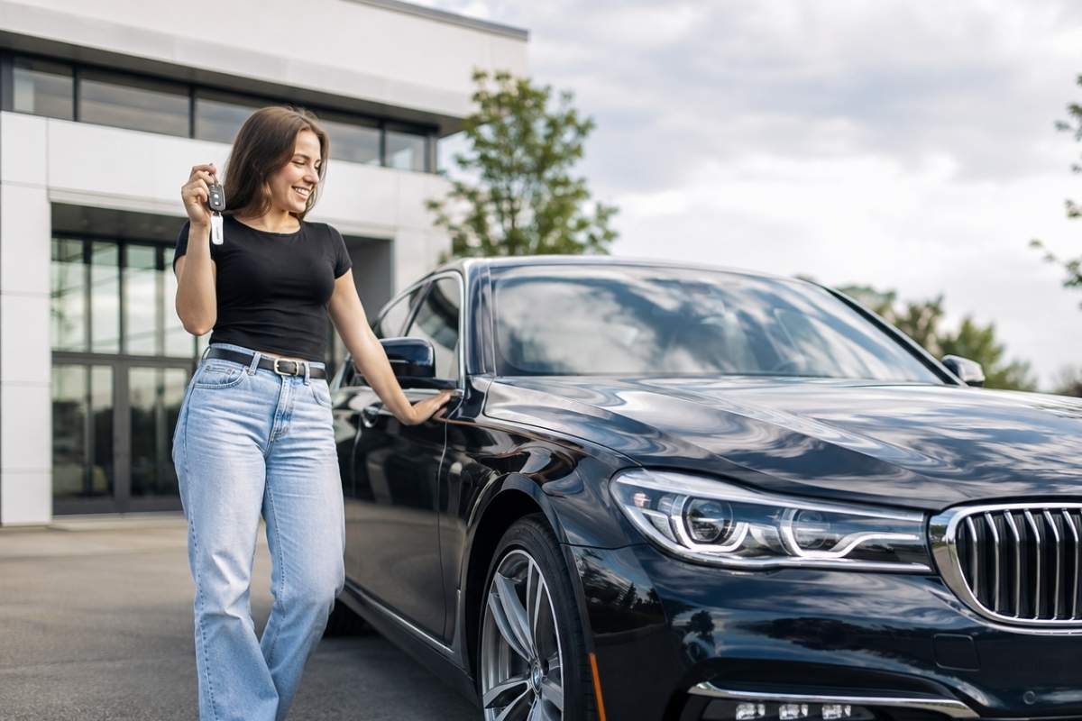 Uma mulher olhando para o carro que conseguiu tirar do papel