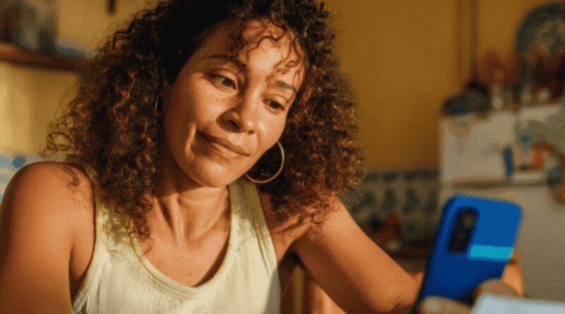 Mulher preocupada vendo benefício atrasado