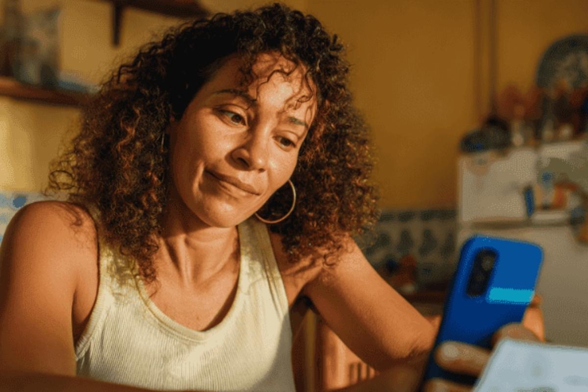 Mulher preocupada vendo benefício atrasado