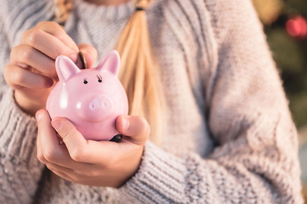 Uma pessoa guardando moeda no cofre com disciplina financeira